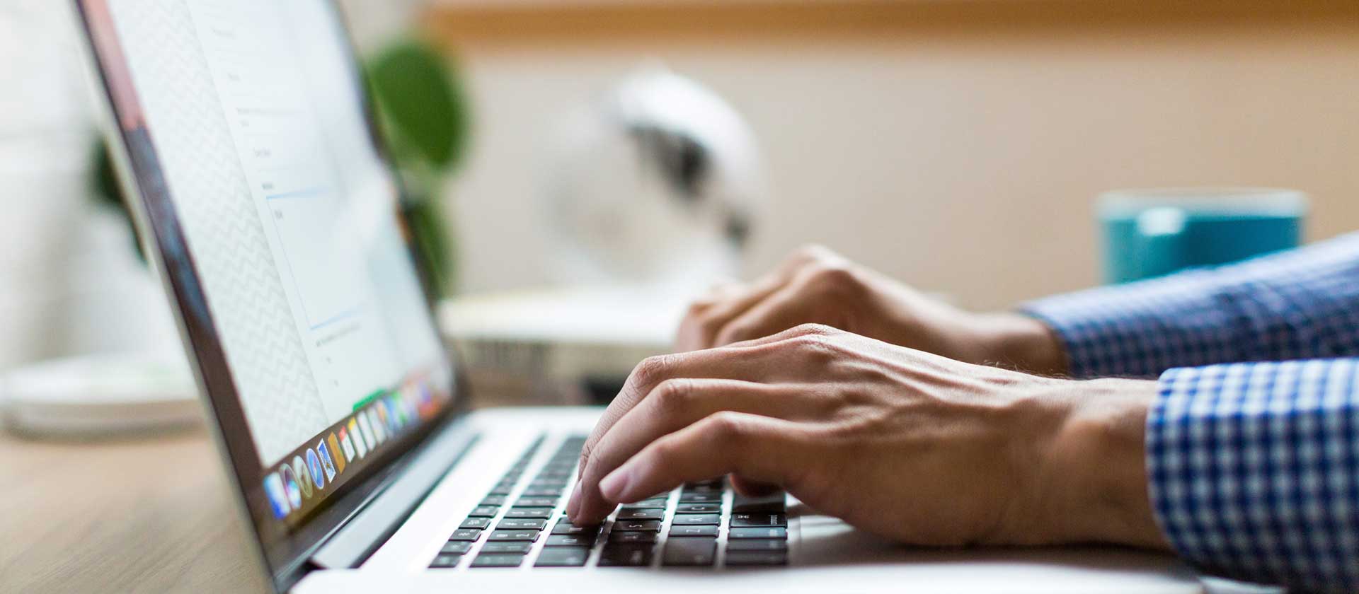 Nahaufnahme von Händen, auf der Tastatur eine Laptops